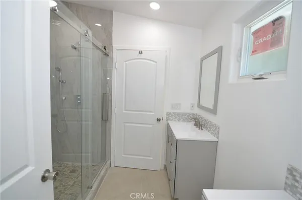 a bathroom with a sink mirror and a shower
