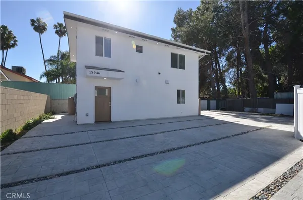 a view of a white house with a street