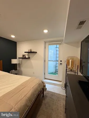 a spacious bedroom with a bed and a flat screen tv