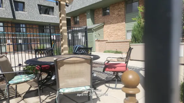 a patio with glass top table and chairs