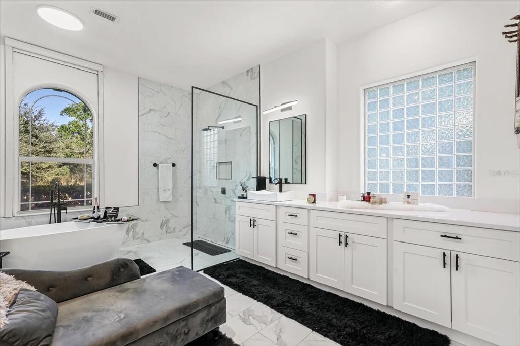 10370 Trout Road Orlando, FL 32836 - Photo 30 of 41 a spacious bathroom with double vanity a mirror a vanity and a bathtub