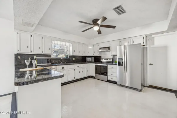 a kitchen with stainless steel appliances a refrigerator sink and cabinets