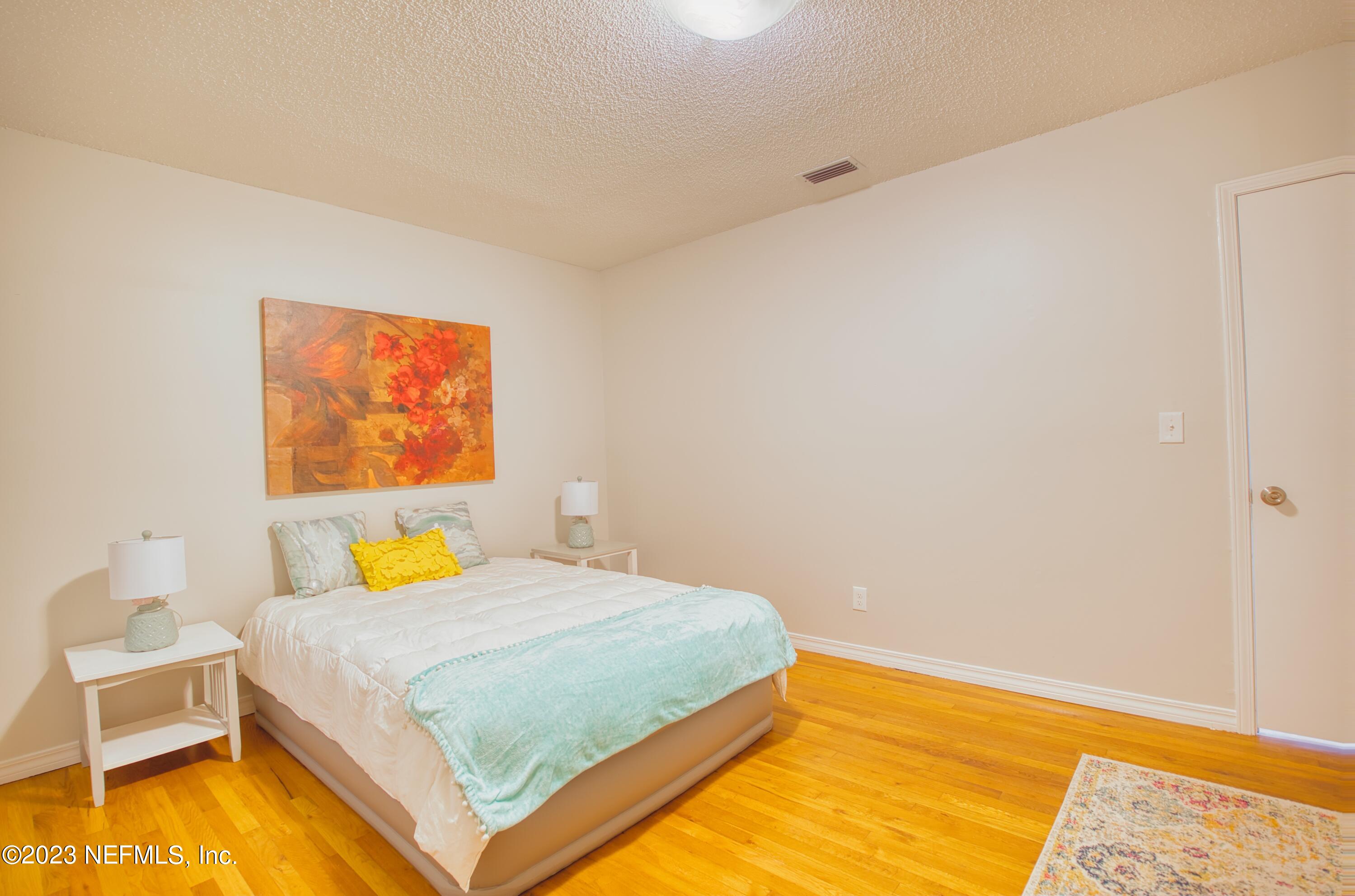 5344 Appleton Avenue Jacksonville, FL 32210 - Photo 15 of 44 a bedroom with a bed and wooden floor
