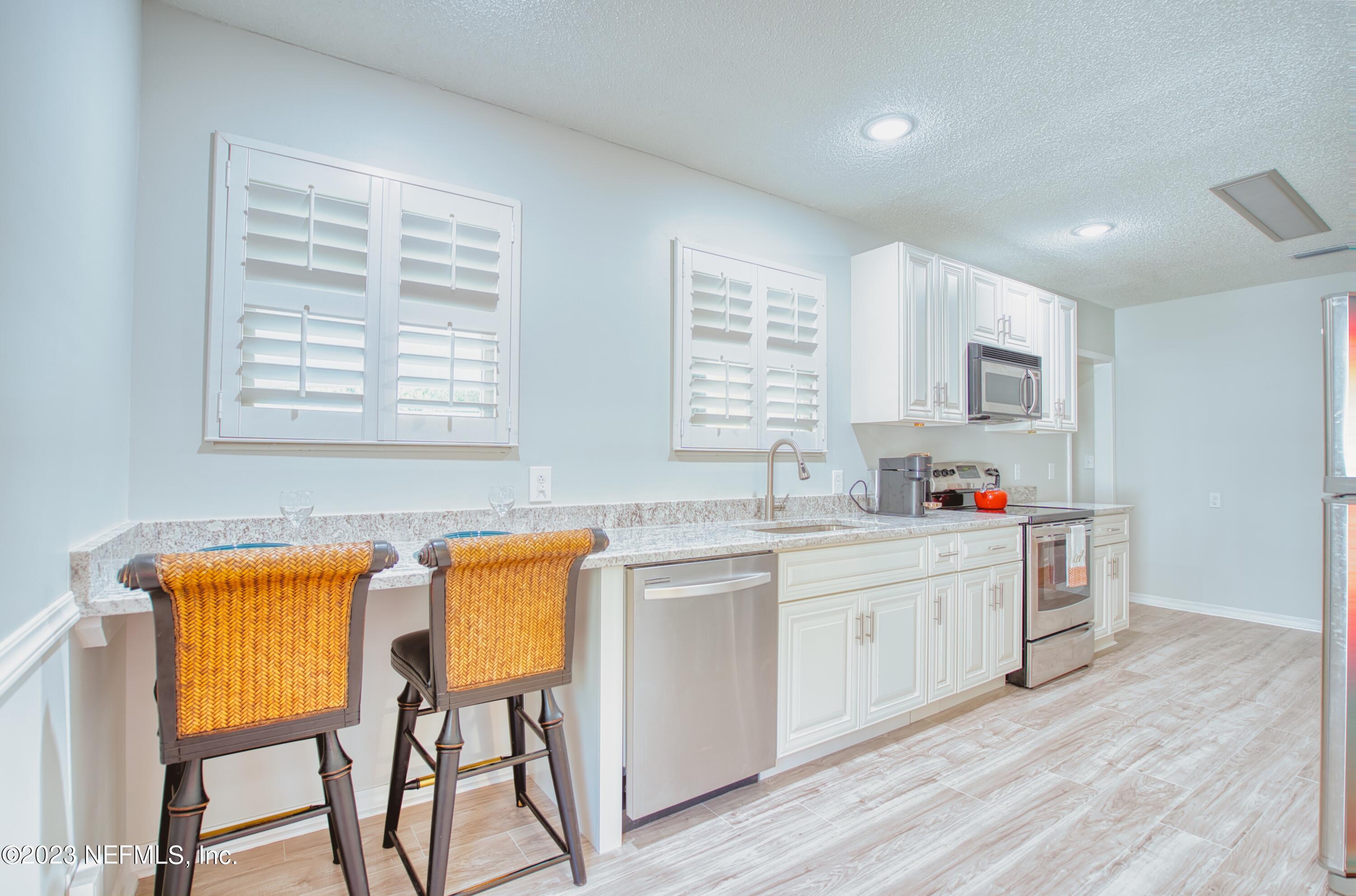 5344 Appleton Avenue Jacksonville, FL 32210 - Photo 8 of 44 a kitchen with stainless steel appliances kitchen island wooden cabinets and center island