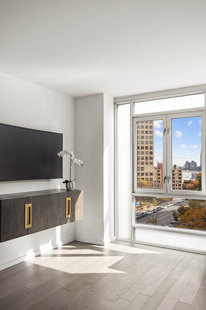 385 1st Avenue, Unit 7F Manhattan, NY 10010 - Photo 3 of 15 a living room with a large window and a flat screen tv