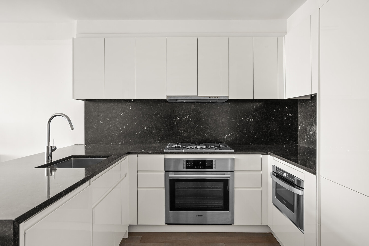 385 1st Avenue, Unit 7F Manhattan, NY 10010 - Photo 6 of 15 a kitchen with granite countertop white cabinets and stainless steel appliances