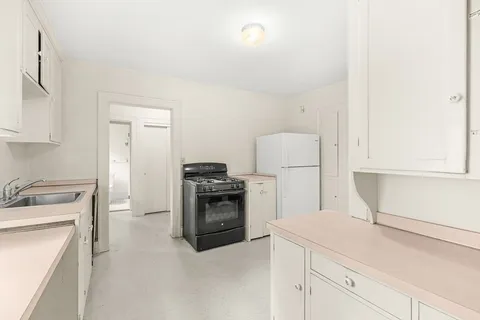 a kitchen with a refrigerator stove and white cabinets