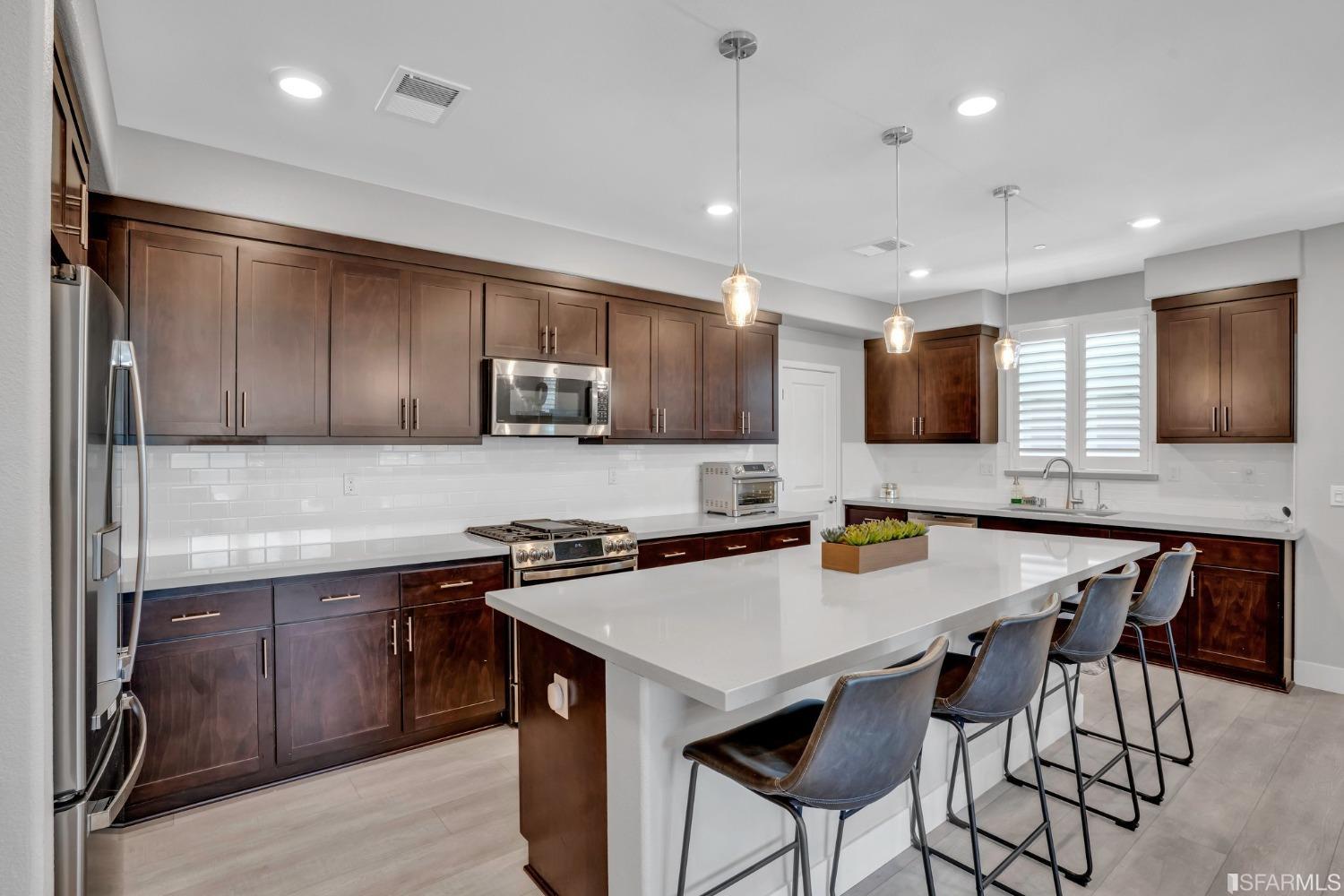 444 Trace Lane Hayward, CA 94544 - Photo 11 of 33 a kitchen with granite countertop a table chairs microwave and cabinets