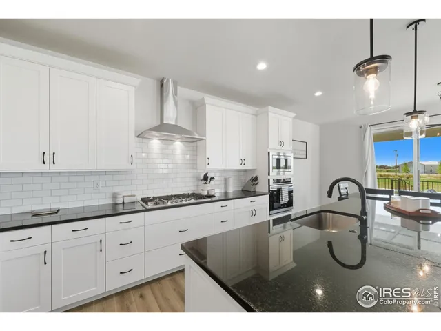 a kitchen with kitchen island granite countertop a sink a stove and cabinets
