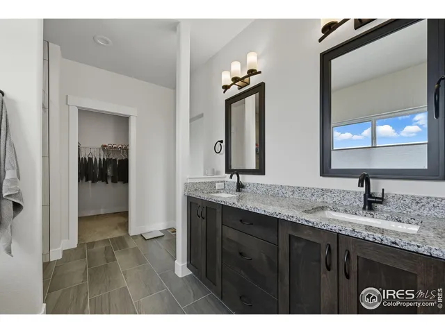 a bathroom with a granite countertop sink two mirror and a