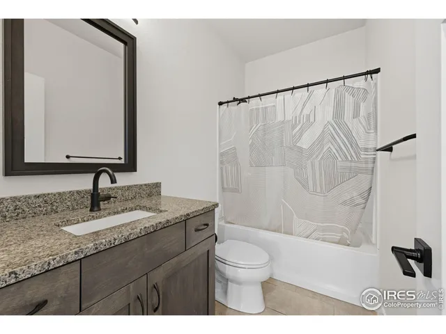 a bathroom with a granite countertop sink a large mirror and a toilet