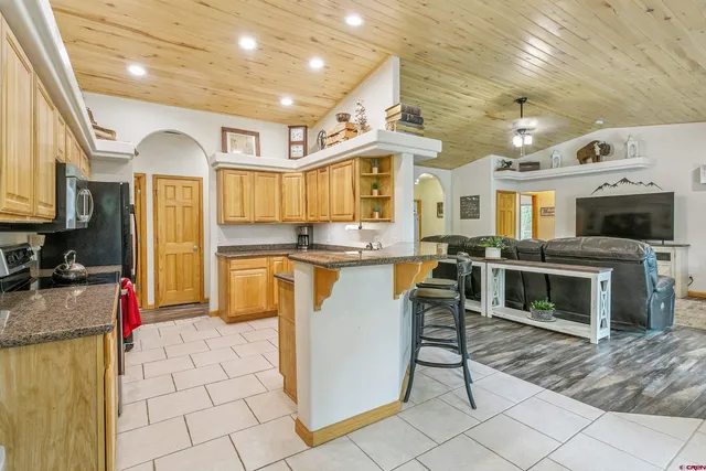 a kitchen with stainless steel appliances granite countertop a stove a sink a microwave and a refrigerator