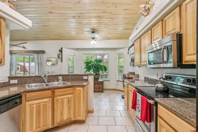 a kitchen with stainless steel appliances granite countertop a sink stove and cabinets