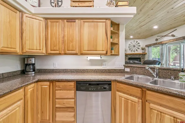 a kitchen with granite countertop a sink window and cabinets