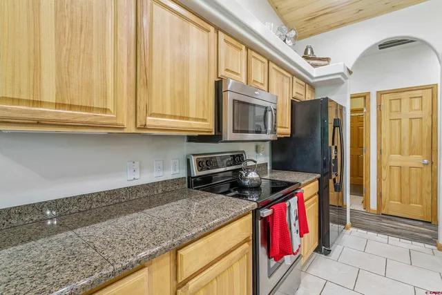 a kitchen with stainless steel appliances granite countertop a stove a sink and a microwave