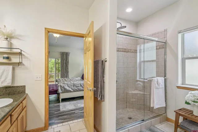 a en suite spacious bathroom with a granite countertop tub shower and sink