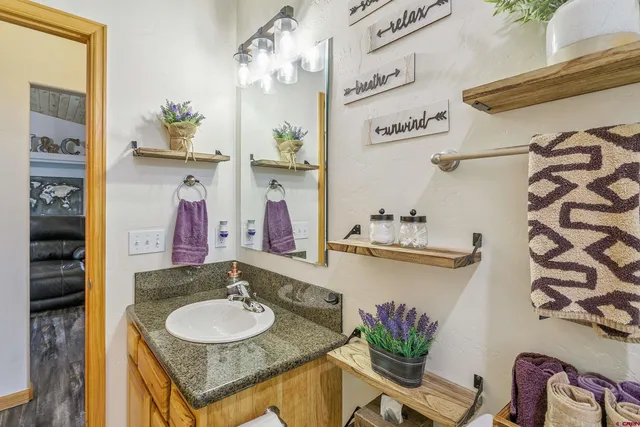 a bathroom with a granite countertop sink a mirror and a shower curtain