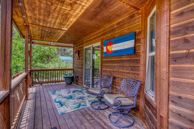 a balcony with wooden floor table and chairs
