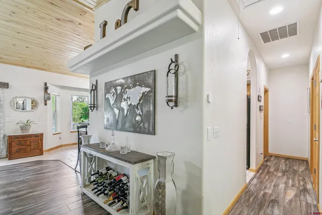 a view of a hallway with wooden floor and furniture