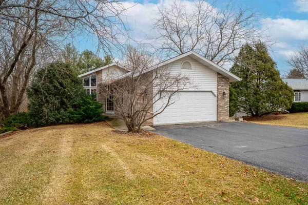 a open kitchen with stainless steel appliances granite countertop a stove top oven a sink a dining table and chairs with wooden floor