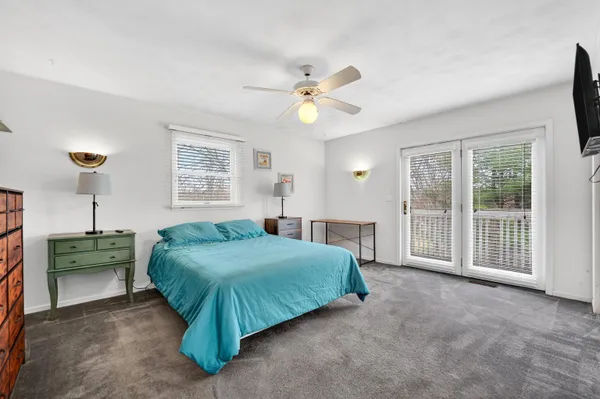 a spacious bedroom with a bed and a chandelier