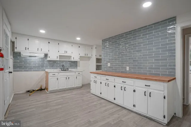 a kitchen with granite countertop white cabinets white stainless steel appliances with a sink and dishwasher