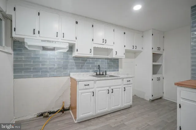 a kitchen with a sink stove and cabinets