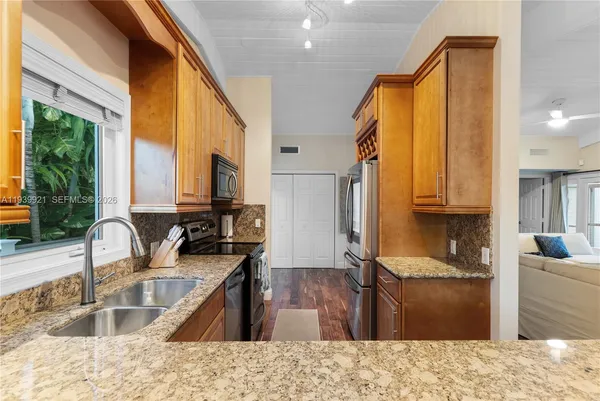 a kitchen with a granite countertop sink and a large window