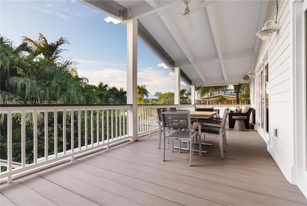 a view of a patio with table and chairs and floor to ceiling window with wooden floor