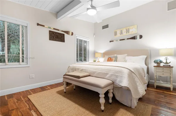 a bedroom with a bed and wooden floor