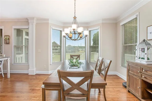 a kitchen with granite countertop stainless steel appliances a dining table and a large window