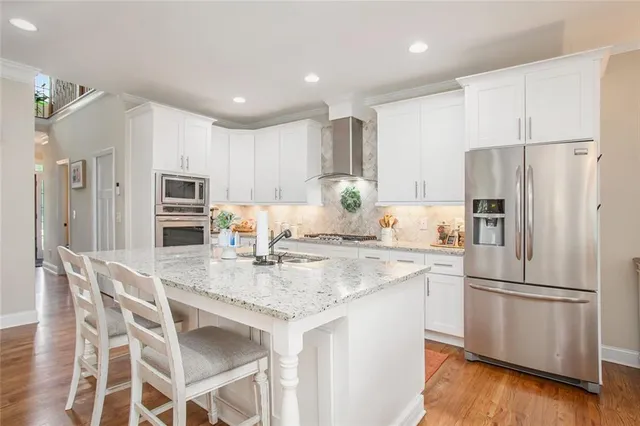a large kitchen with granite countertop a sink and white cabinets