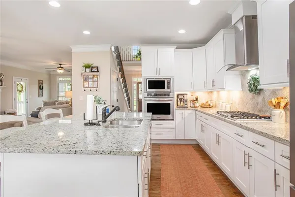 a kitchen with granite countertop a stove and a white cabinets