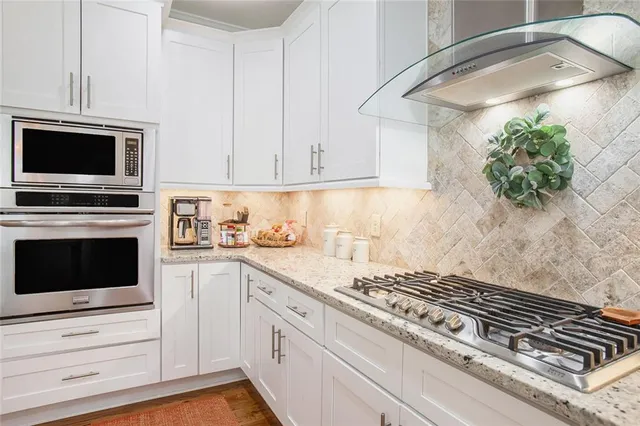 a kitchen with granite countertop kitchen island stainless steel appliances a sink and a center island