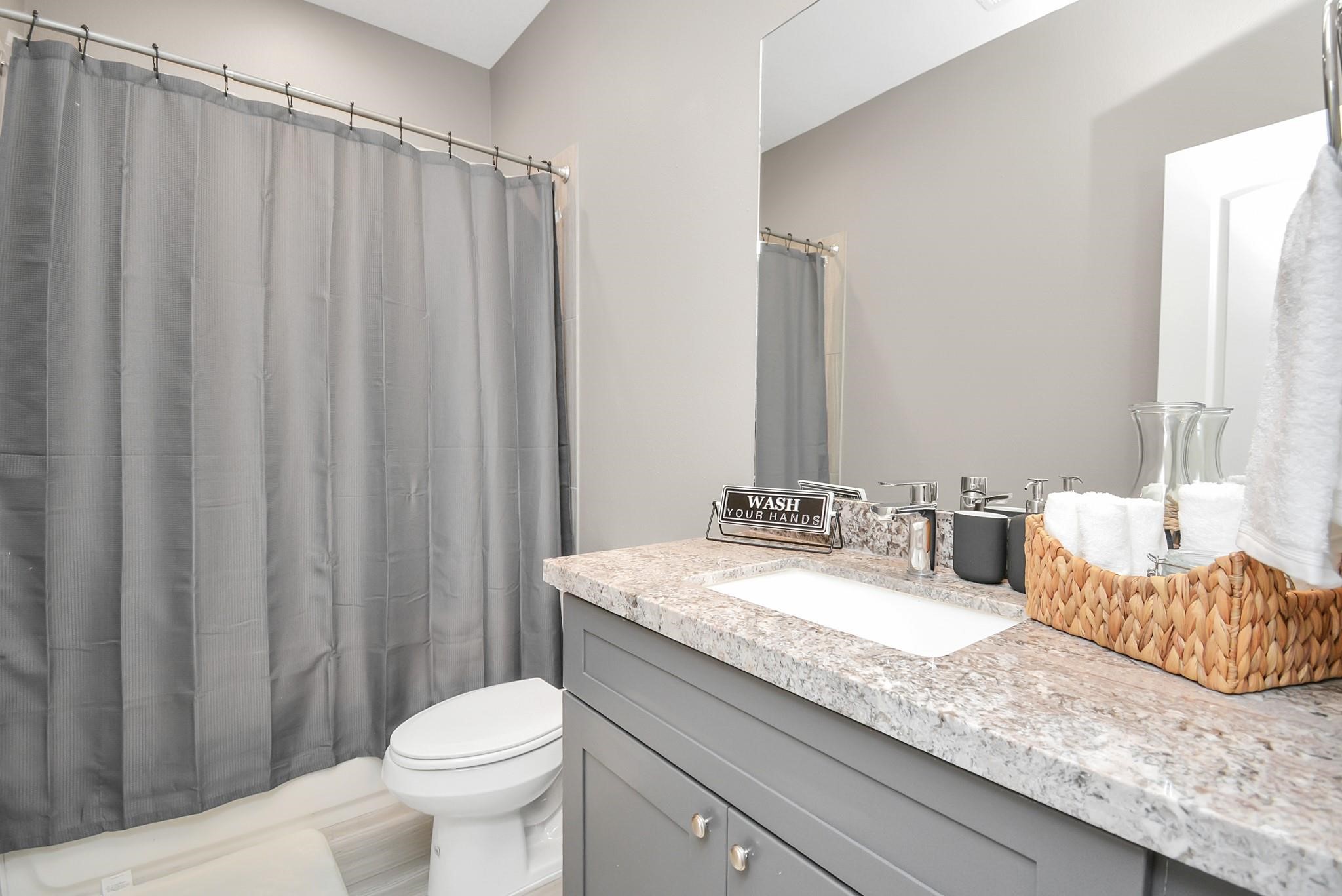 3019 Elysian Street Houston, TX 77009 - Photo 25 of 33 a bathroom with a granite countertop sink a toilet and a mirror