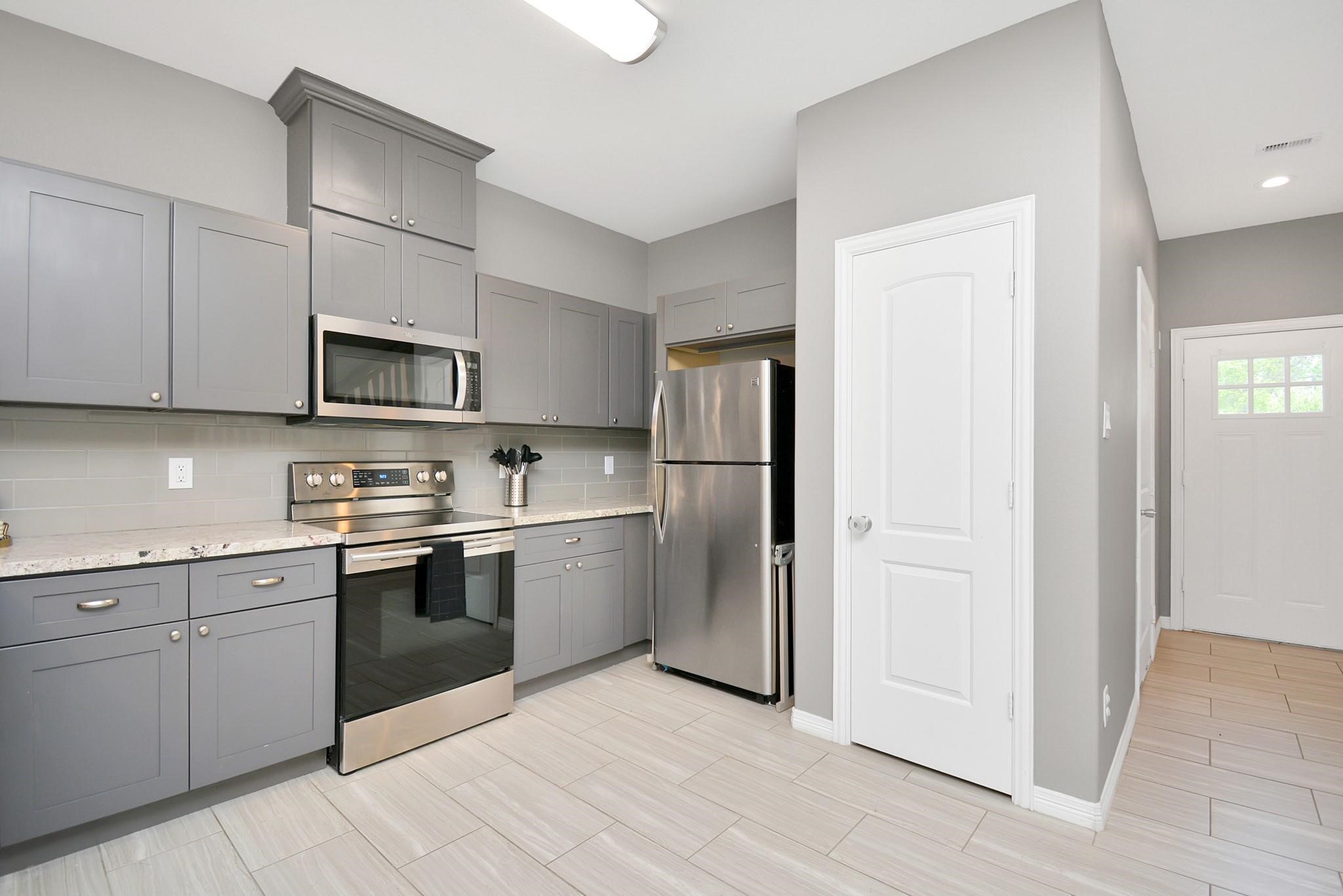 3019 Elysian Street Houston, TX 77009 - Photo 7 of 33 a kitchen with stainless steel appliances granite countertop a refrigerator and a stove top oven
