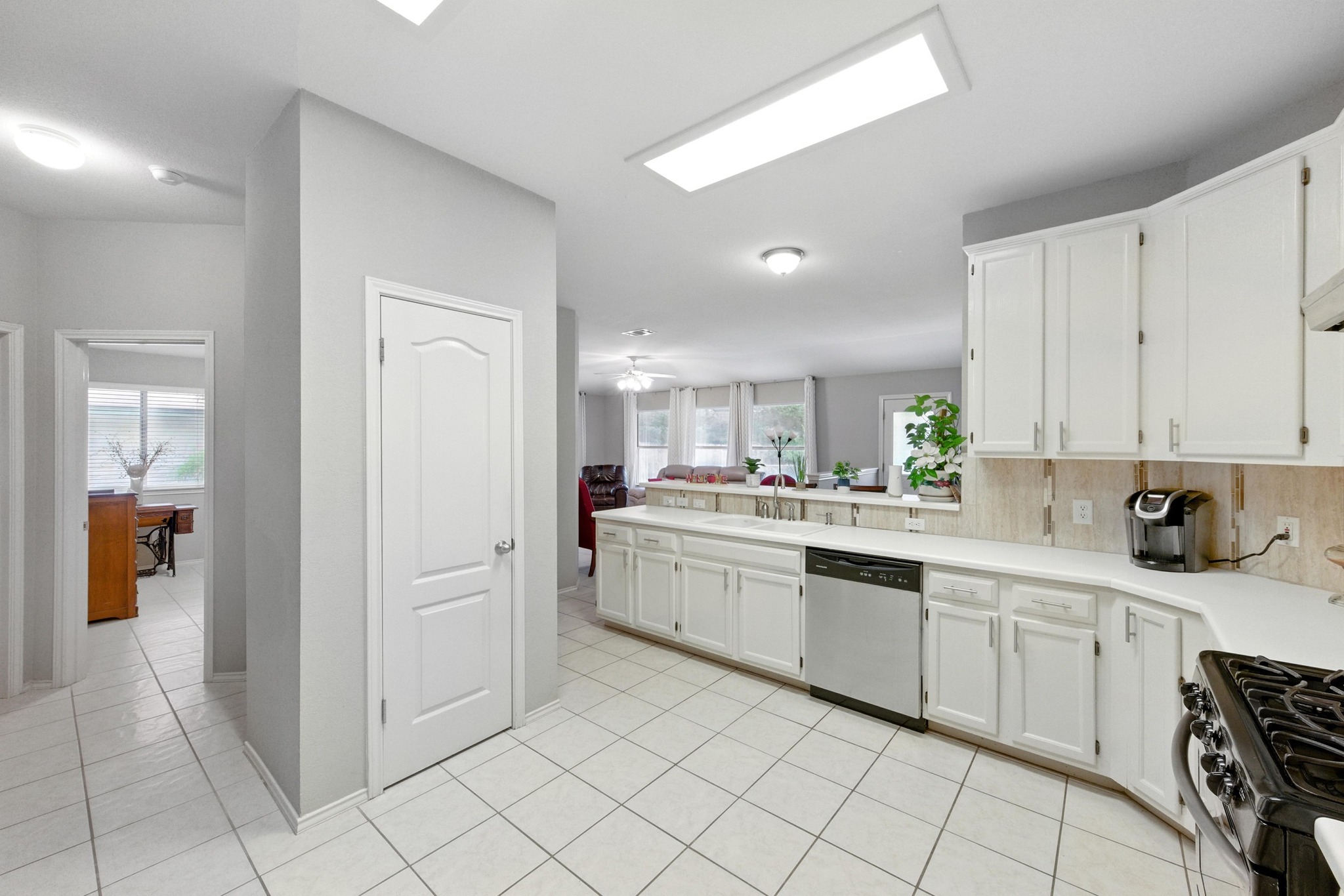 9602 Tea Rose Trail Austin, TX 78748 - Photo 12 of 27 Kitchen with light countertops, stainless steel dishwasher, decorative backsplash, and light tile patterned floors