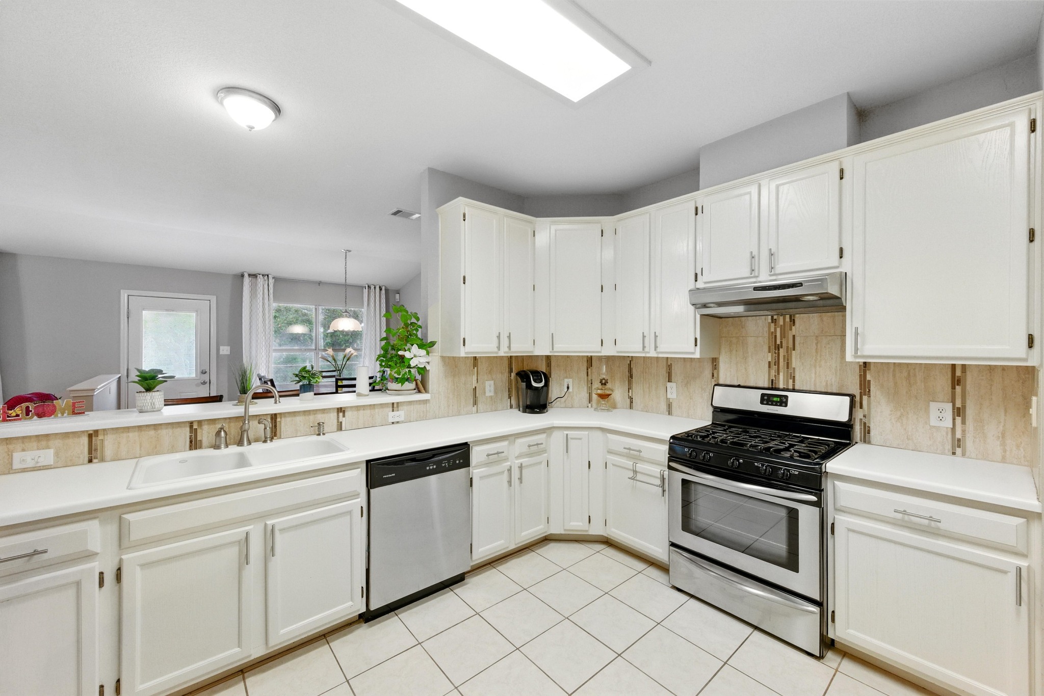 9602 Tea Rose Trail Austin, TX 78748 - Photo 13 of 27 Kitchen featuring stainless steel appliances, light countertops, light tile patterned floors, and white cabinetry