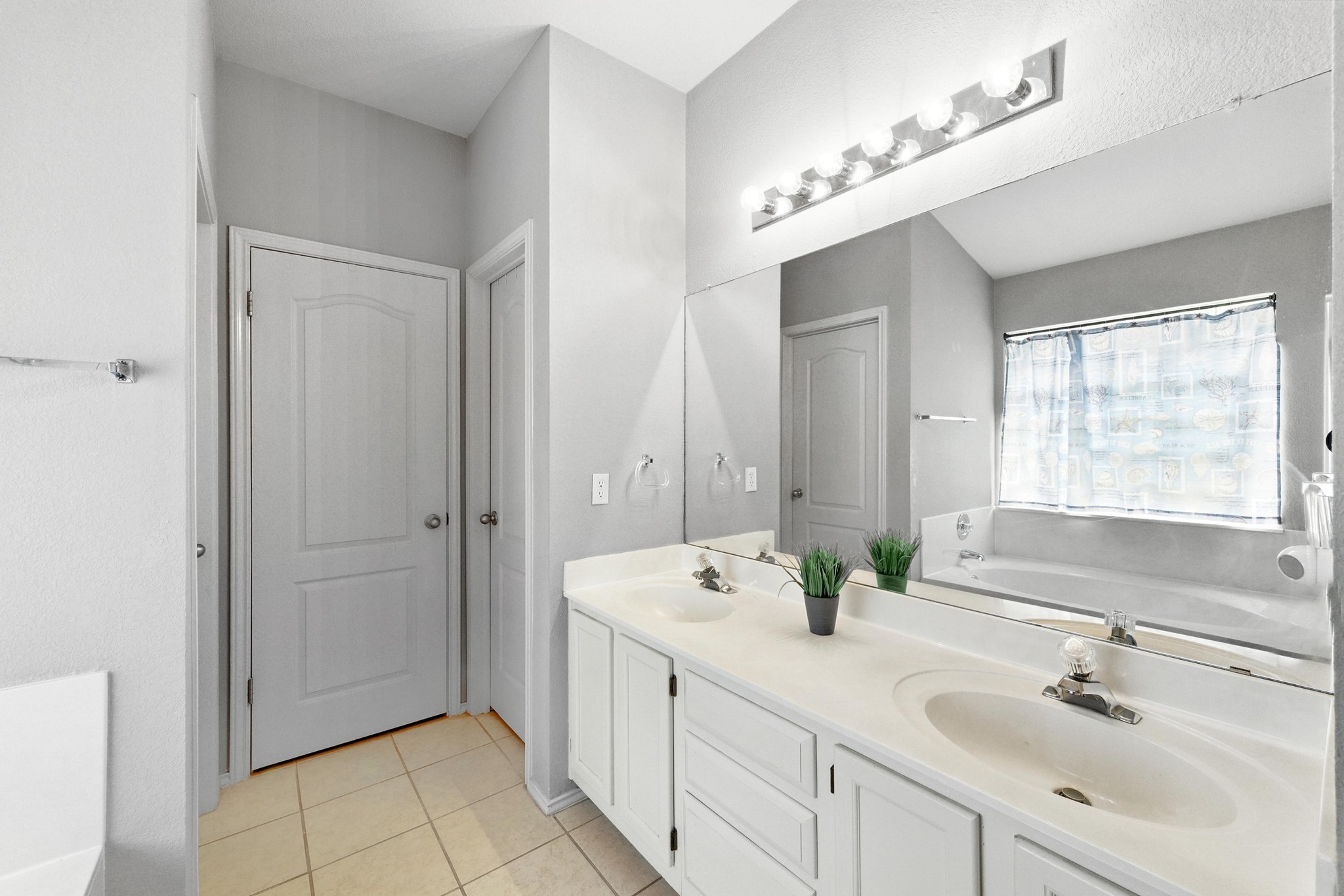 9602 Tea Rose Trail Austin, TX 78748 - Photo 19 of 27 Full bathroom featuring a bath, double vanity, and light tile patterned flooring