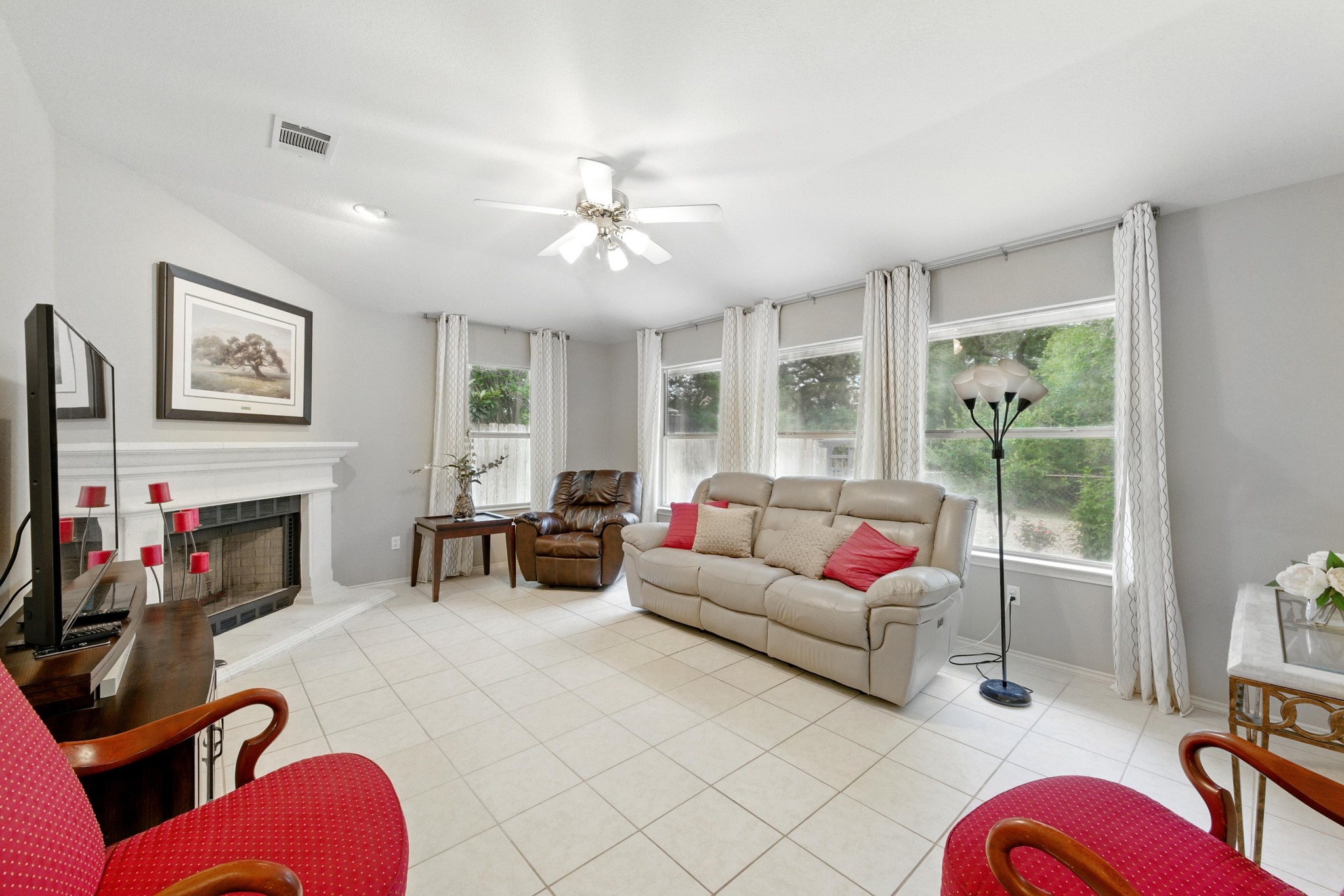 9602 Tea Rose Trail Austin, TX 78748 - Photo 8 of 27 Living room featuring a ceiling fan, light tile patterned floors, and a fireplace with raised hearth
