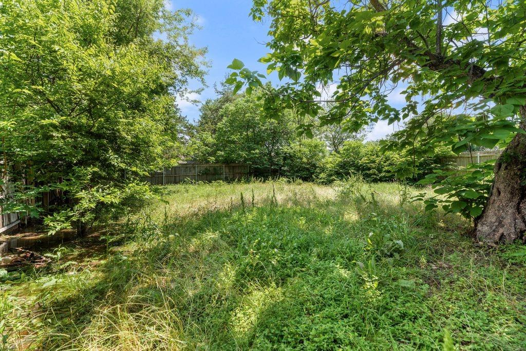 2526 Exeter Avenue Dallas, TX 75216 - Photo 18 of 19 Expansive grassy lot with mature perimeter trees, offering natural landscaping and partial fencing