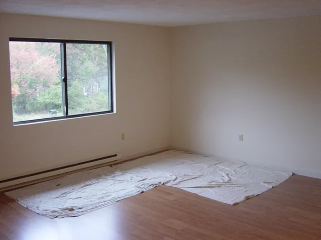 a view of a room with wooden floor and window