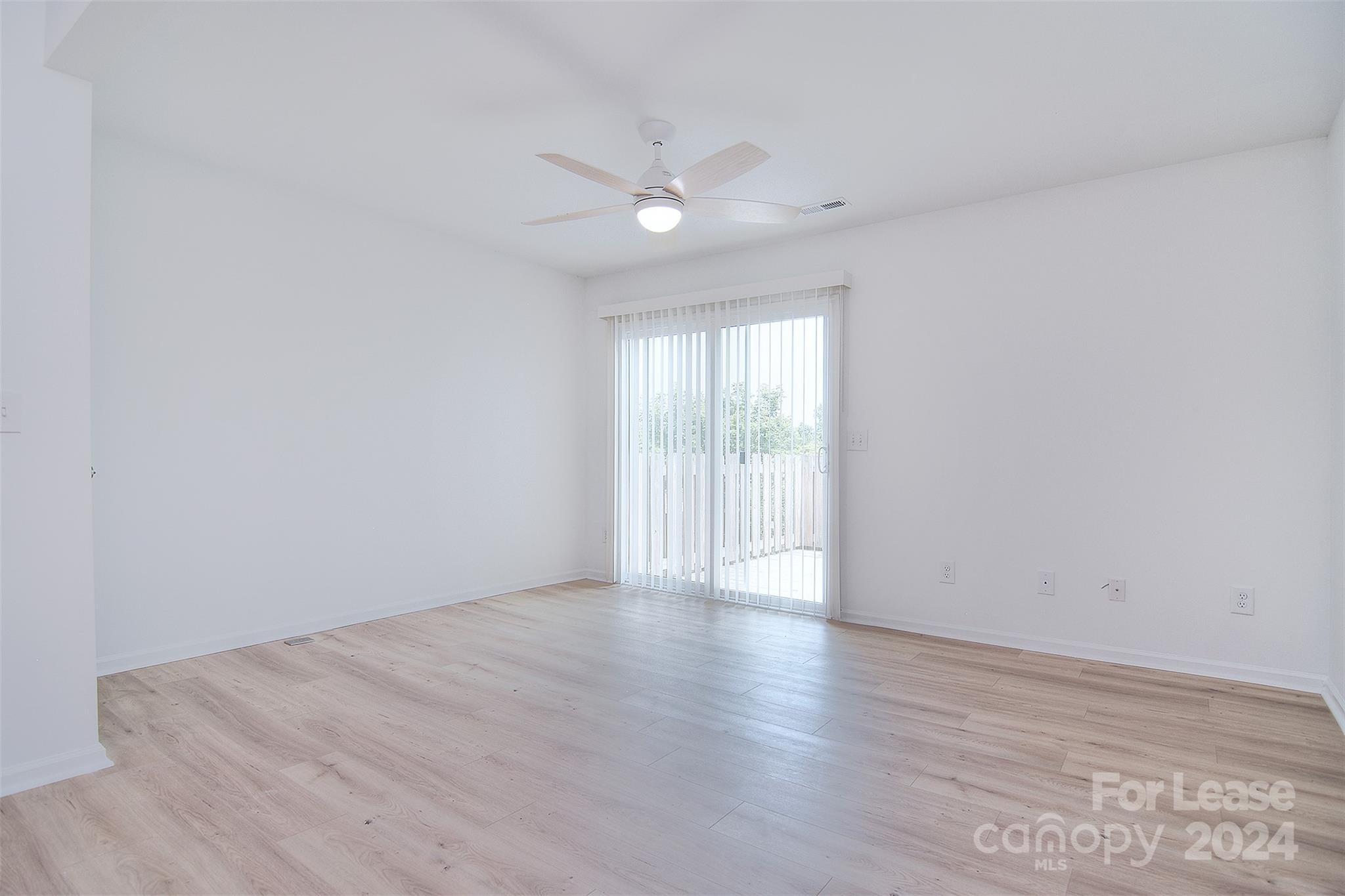 660 Lex Drive Charlotte, NC 28262 - Photo 15 of 16 a view of an empty room with wooden floor and a ceiling fan
