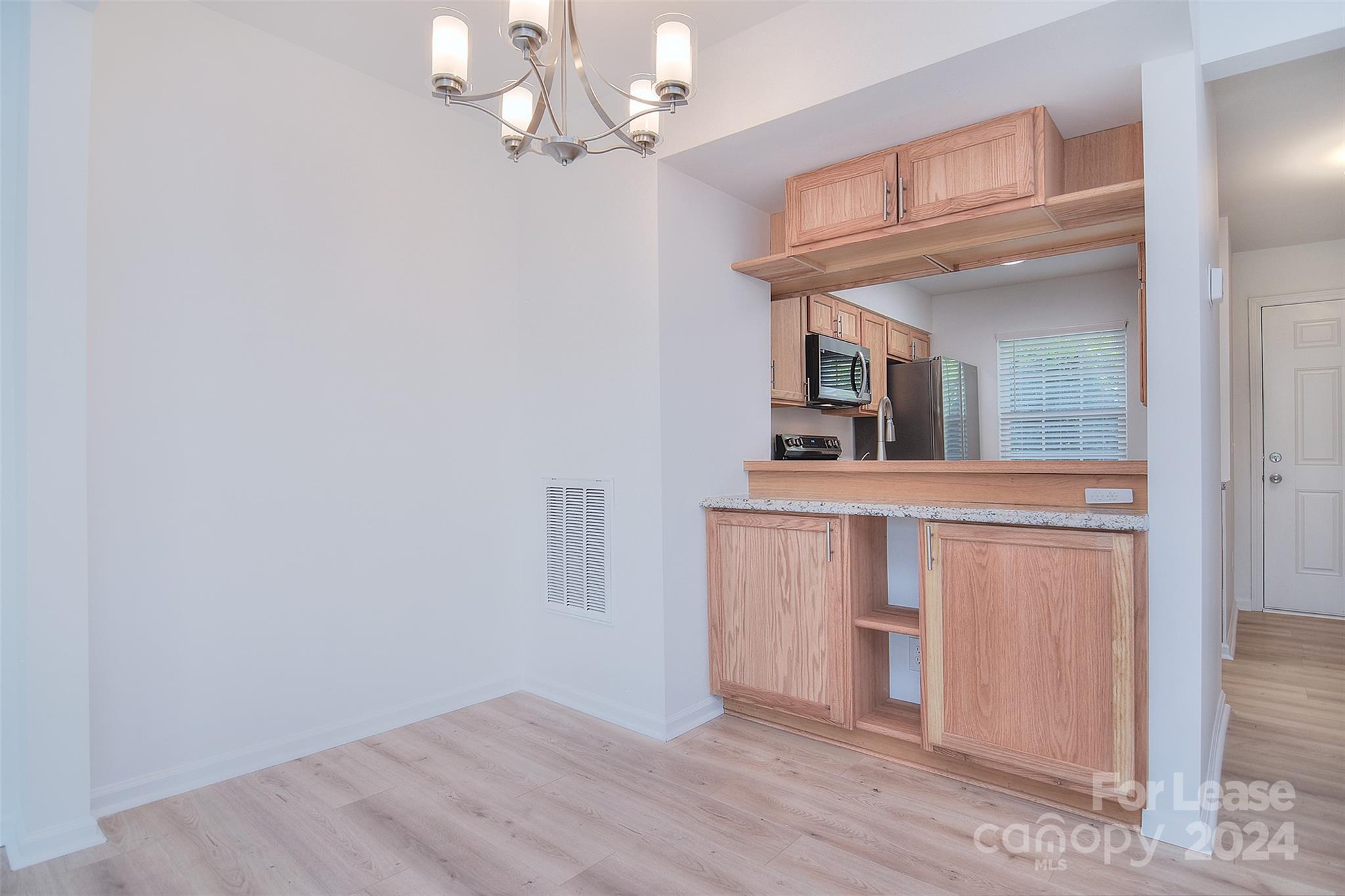 660 Lex Drive Charlotte, NC 28262 - Photo 5 of 16 a view of a hallway with wooden floor and a kitchen space