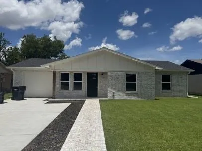 a front view of house with yard and trees in the background