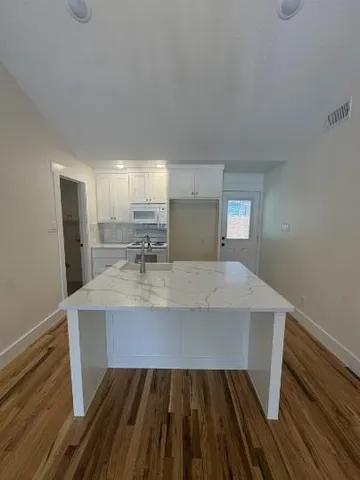 a view of kitchen with sink and refrigerator