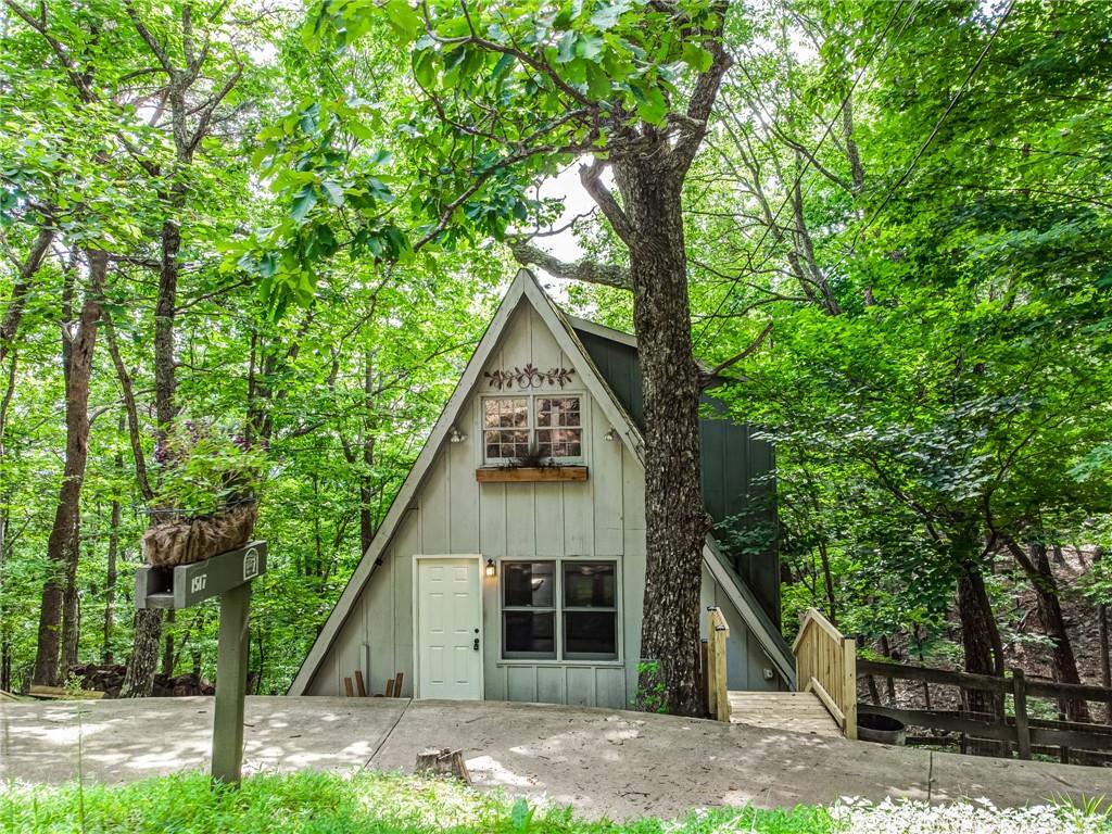 a front view of a house with a tree