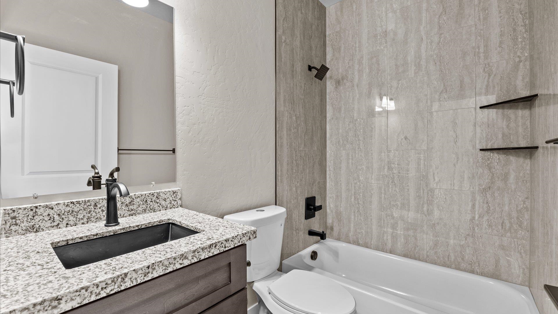 2642 B B 1/2 Road Grand Junction, CO 81503 - Photo 13 of 25 a bathroom with a granite countertop sink a toilet and bathtub
