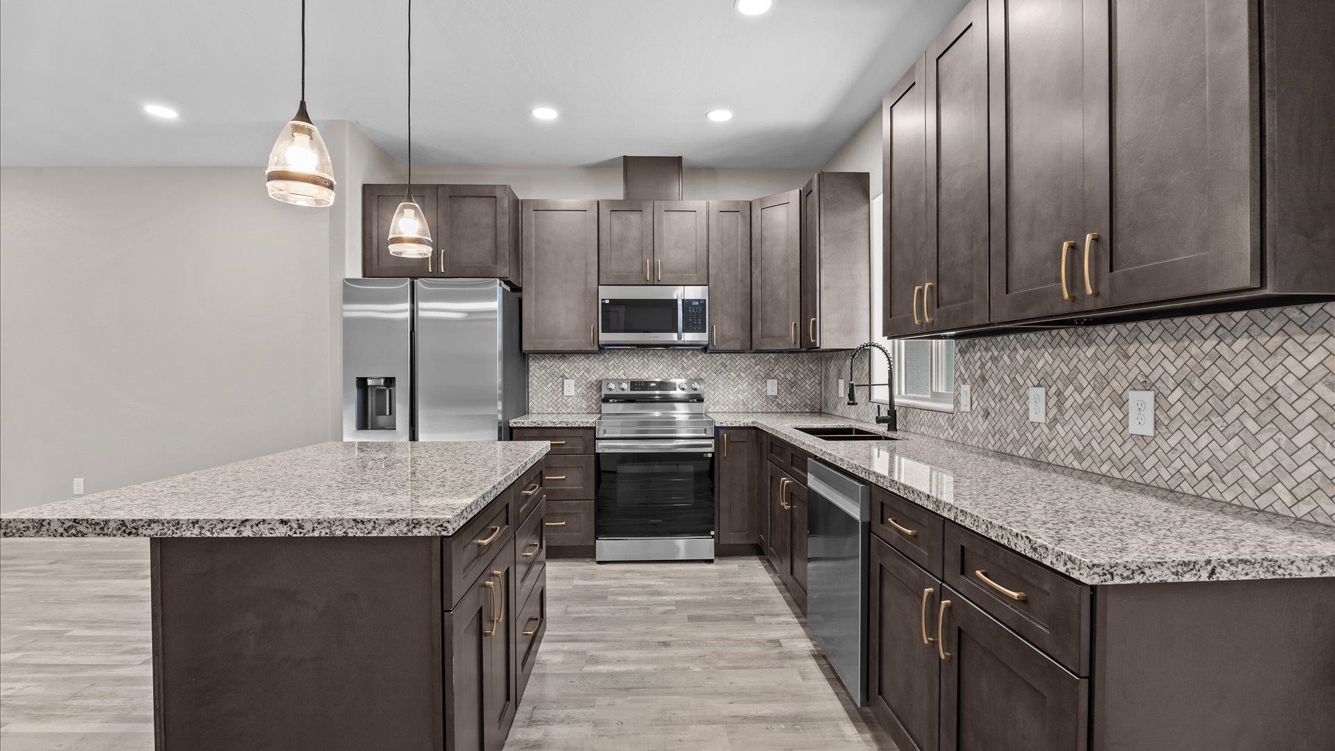 2642 B B 1/2 Road Grand Junction, CO 81503 - Photo 8 of 25 a kitchen with granite countertop kitchen island stainless steel appliances a sink stove and refrigerator