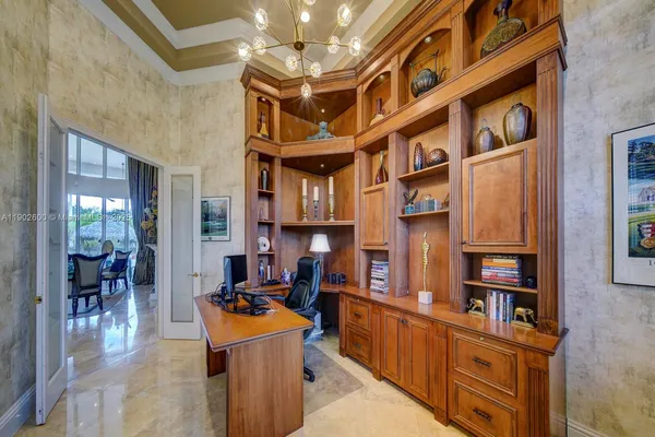 a living room with furniture cabinets and a chandelier